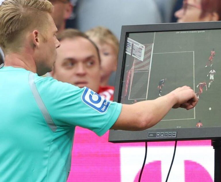 Wasit meninjau tayangan VAR dalam pertandingan sepak bola Indonesia untuk menentukan keputusan penting di lapangan
