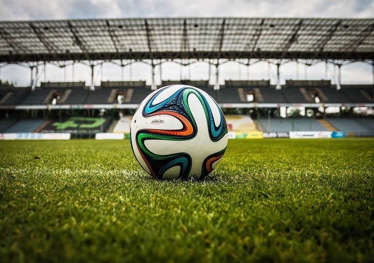 Pemain sepak bola modern sedang bertanding dengan dukungan teknologi analisis data dan VAR di stadion
