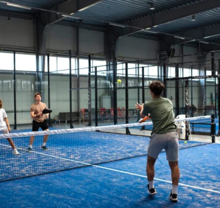 Pemain pickleball sedang bertanding di lapangan olahraga modern