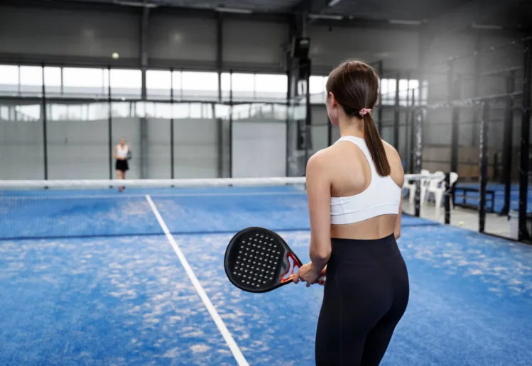 Pemain pickleball sedang bertanding di lapangan olahraga dengan suasana kompetitif dan aktif